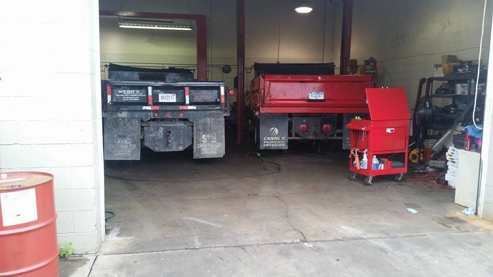Two dump trucks in the open bays at Winners Diesel in Brownstown